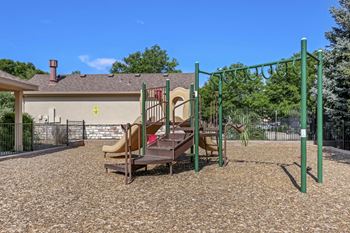 A playground with a slide and swings in a residential area.